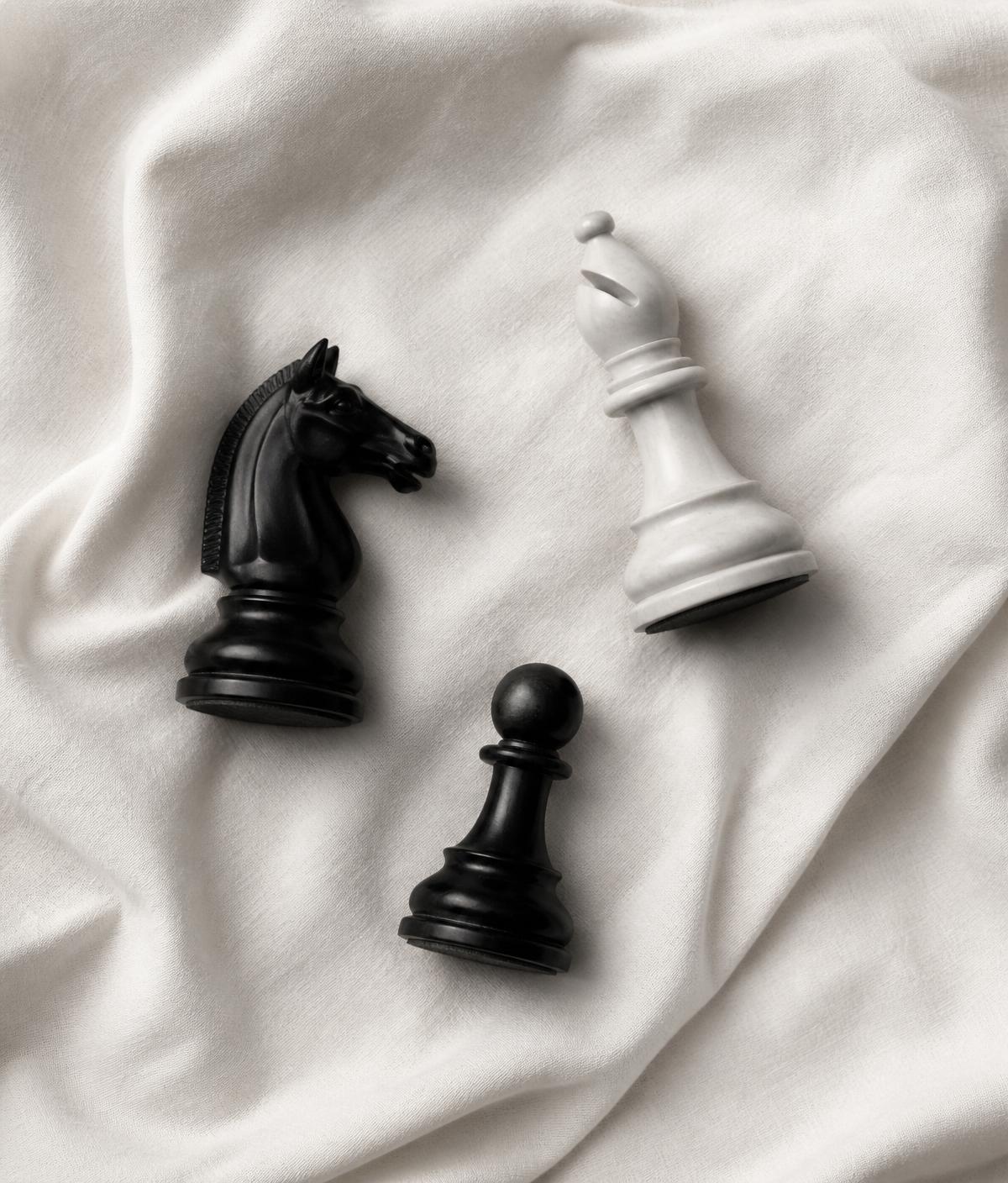 Knight, bishop and pawn arranged on linen