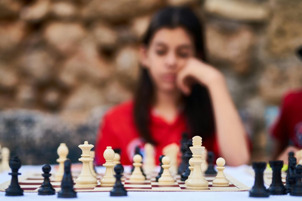Child thinking while playing chess during a learning session